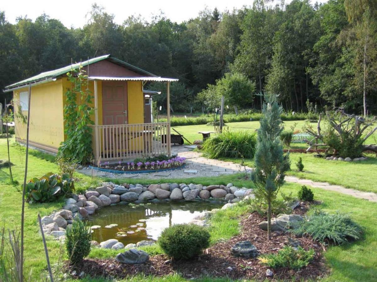 rustic-design-of-a-small-house-with-pond-in-front-yard-plus-garden